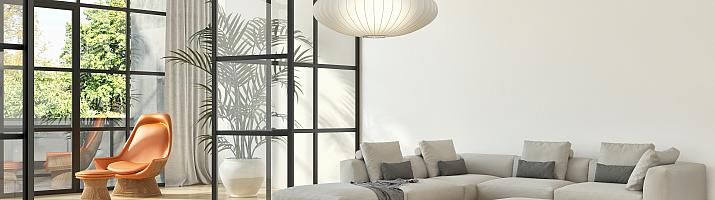 Modern living room with a large black steel-replacement screen and an open pivot door leading to a sunroom
