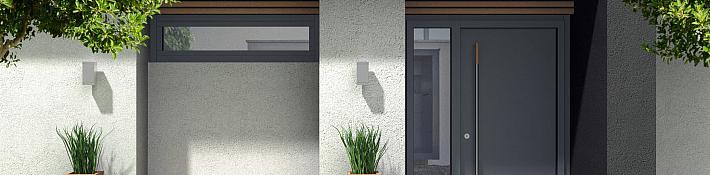 A modern, solid dark grey entrance door with a long vertical handle, set into a contemporary house exterior with wood slat details