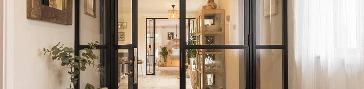 Open black Origin OI-30 internal door with side panels and solid bottom, in a rustic hallway with wooden floors