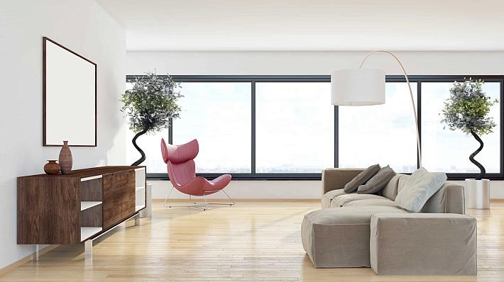 Minimalist living room with a large, dark-framed aluminium window wall providing a wide view