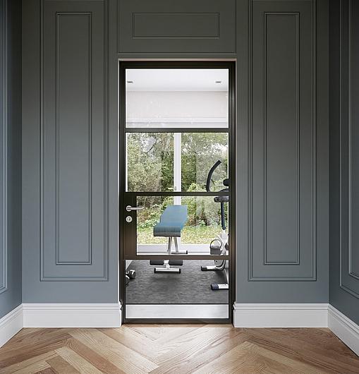 A single black Origin OI-30 internal door with a mid-rail, set in a grey panelled wall and leading into a home gym