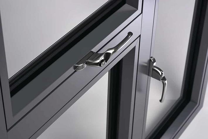 Close-up of a dark grey aluminium window, showing the modern chrome casement handle
