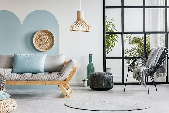 Living room with a futon and a large black, industrial-style aluminium window screen with a grid pattern