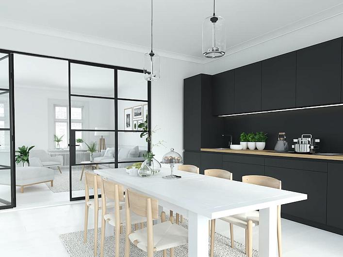 A black steel-replacement screen with a sliding door, separating a modern black kitchen from a bright living area