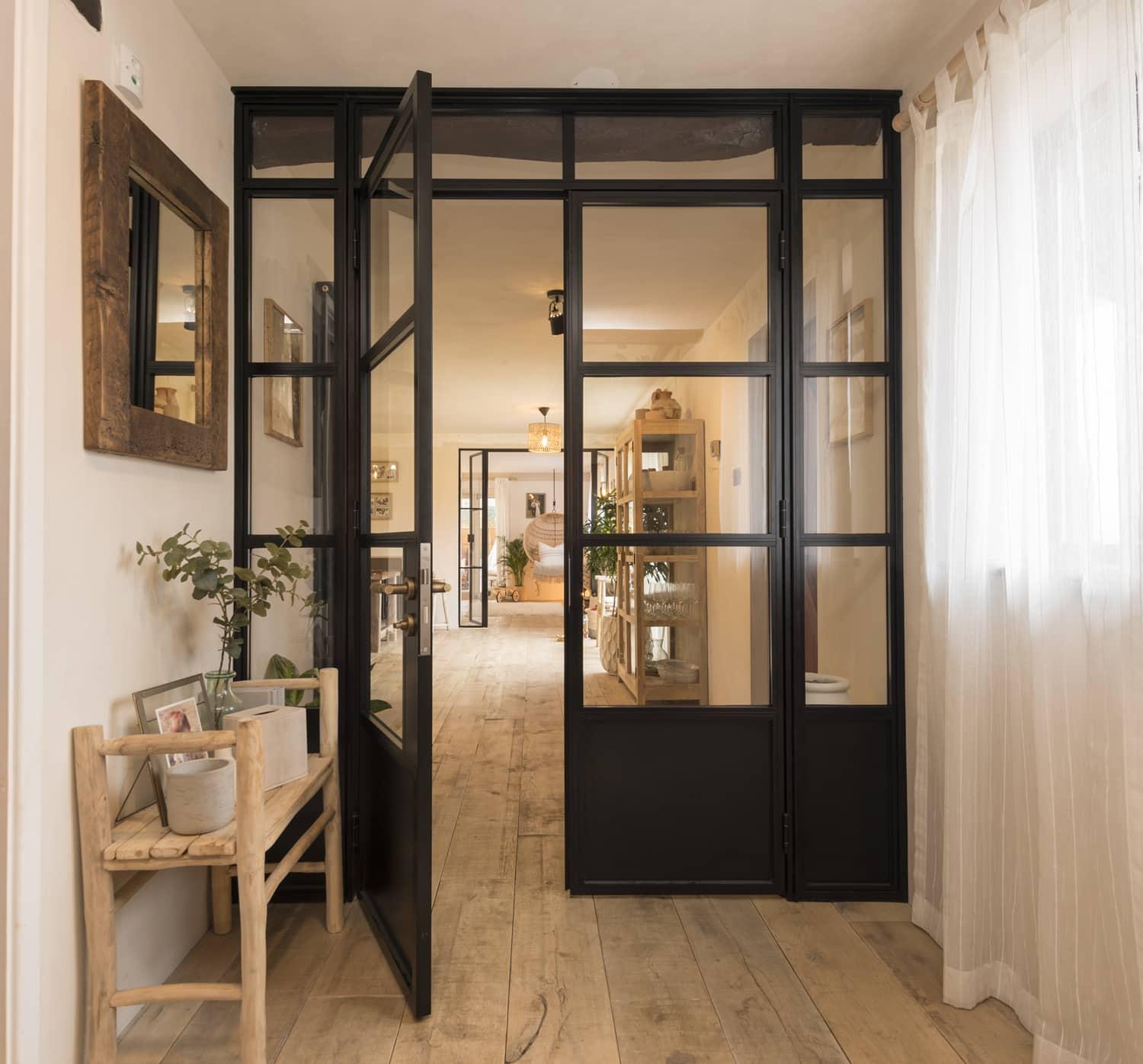 Open black Origin OI-30 internal door with side panels and solid bottom, in a rustic hallway with wooden floors