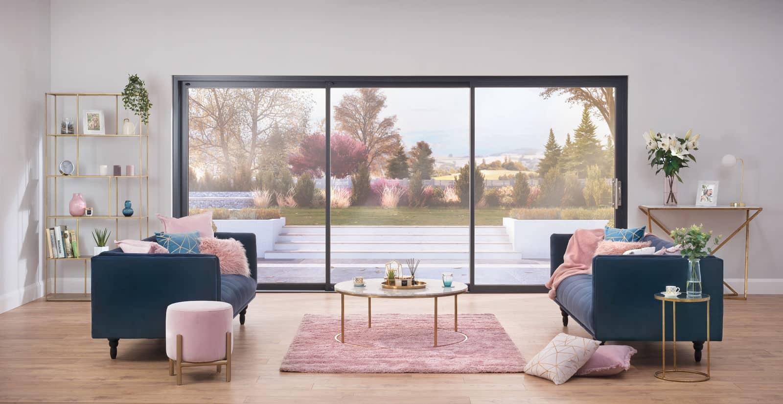 Stylish living room with two armchairs, looking out through a large, black-framed sliding door onto a patio