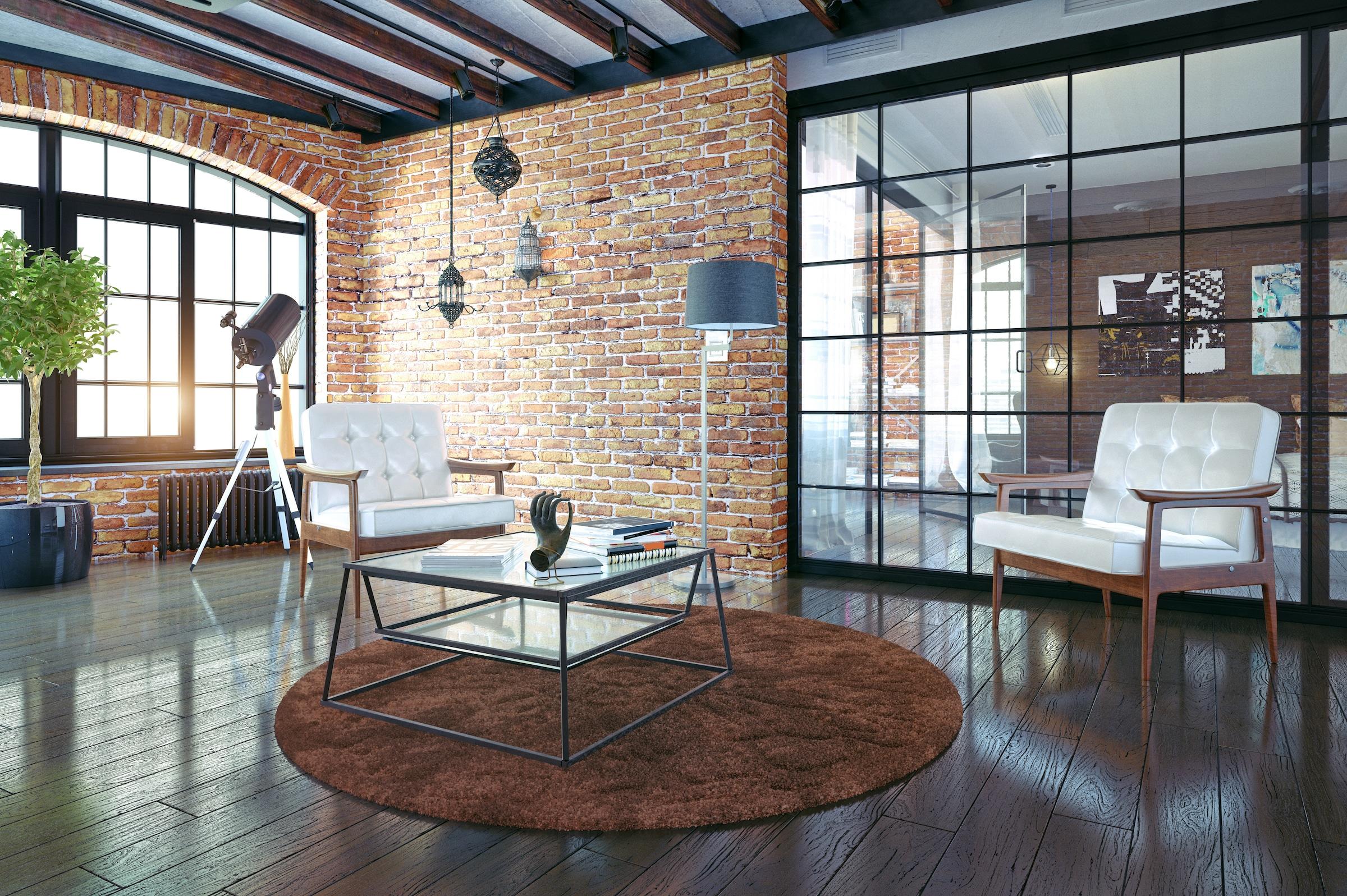 An industrial-style room with brick walls, featuring a large black steel-replacement window and a matching internal screen