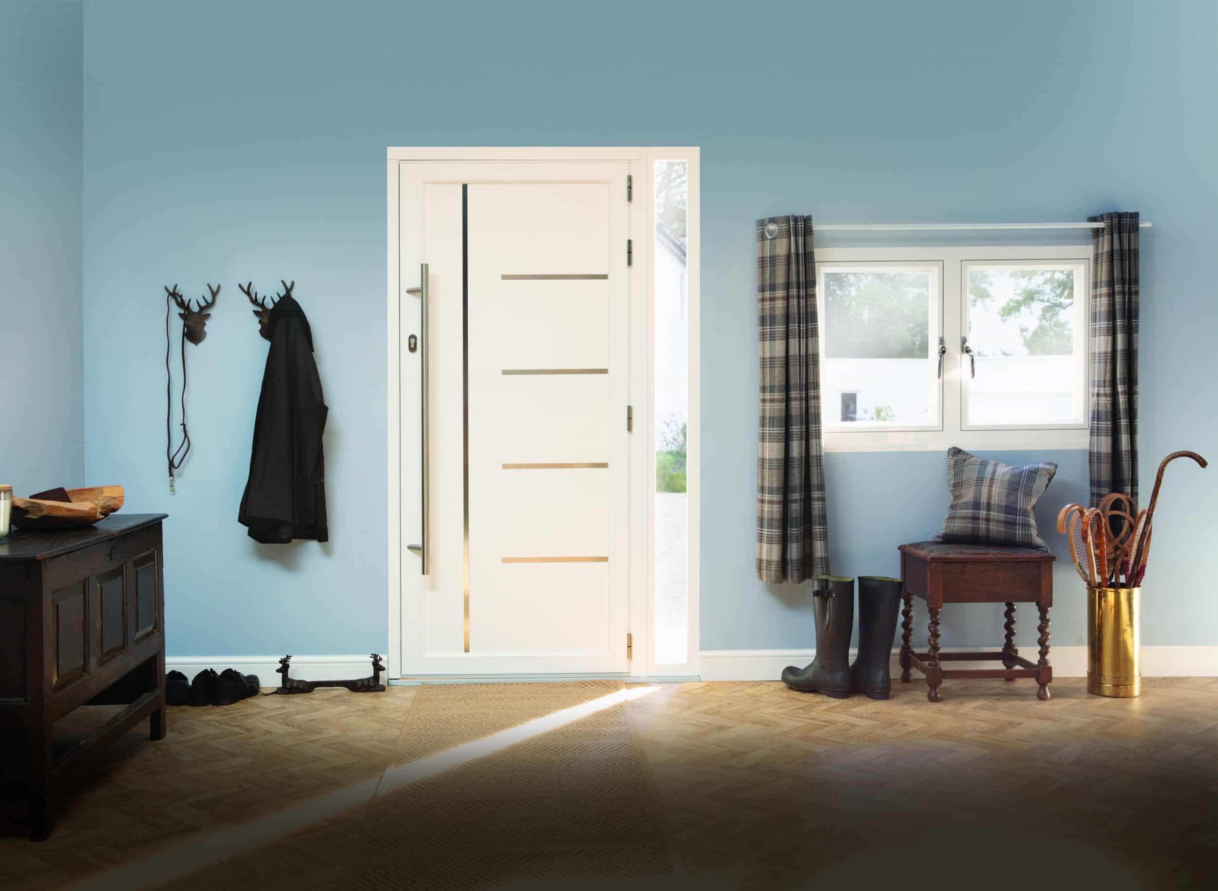 Modern white Origin front door with horizontal strips and a long handle, viewed from inside a light blue entrance hall