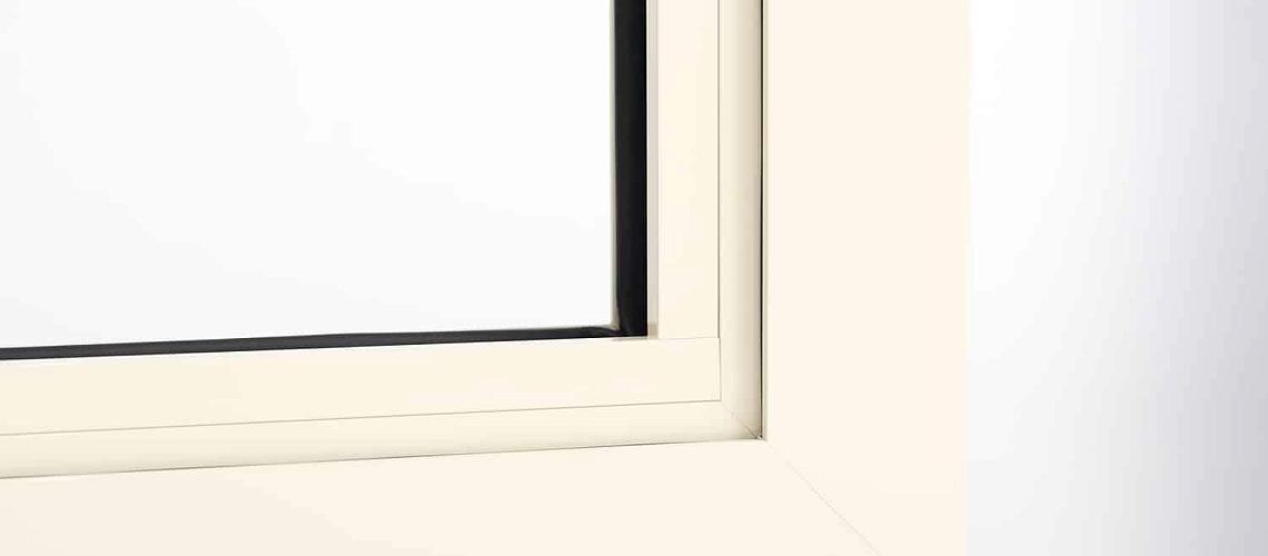 A macro shot of the corner joint on a cream-coloured Origin window frame, showing the slim profile