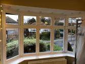 Wide view of the house at dusk, showing all the newly installed white Origin windows, including a bay and a dormer window