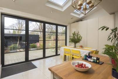 Black Origin OB-49 bifold doors with a steel-look grid, viewed from a modern kitchen, looking onto a patio