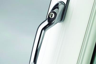 Detailed close-up of a modern, polished chrome handle with a key lock, on a white Alitherm window frame