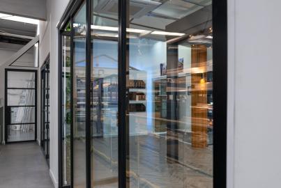 A showroom corridor with a large, multi-panel black slimline patio door installed as a partition