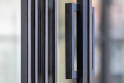 Close-up detail shot of the modern, black, rectangular handle on a slimline patio door
