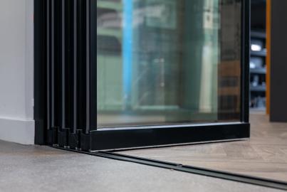Low-angle view of a showroom, showing the low-profile floor track and bottom of a slimline patio door panel