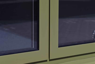 Close-up of an Origin window in a custom pale green finish, showing the frame and sill