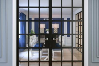 Closed black Origin OI-30 double doors with a full grid pattern, looking from a hallway into a blue dining room