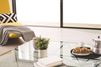 Close-up of a modern living room, showing the low-profile threshold of an Origin sliding door on a light wood floor