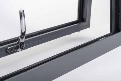 Close-up of an open, dark grey Origin casement window, showing the chrome handle and slim frame
