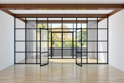 A large black steel-look glass wall with a grid pattern and open double doors, in an empty room with wooden floors