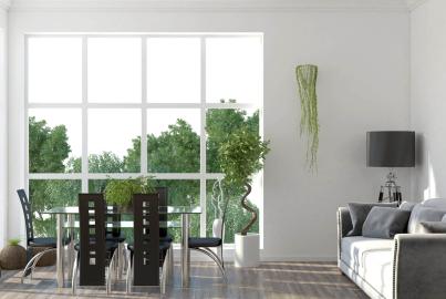 A bright living and dining area with a large, white-framed, steel-look window with a grid pattern