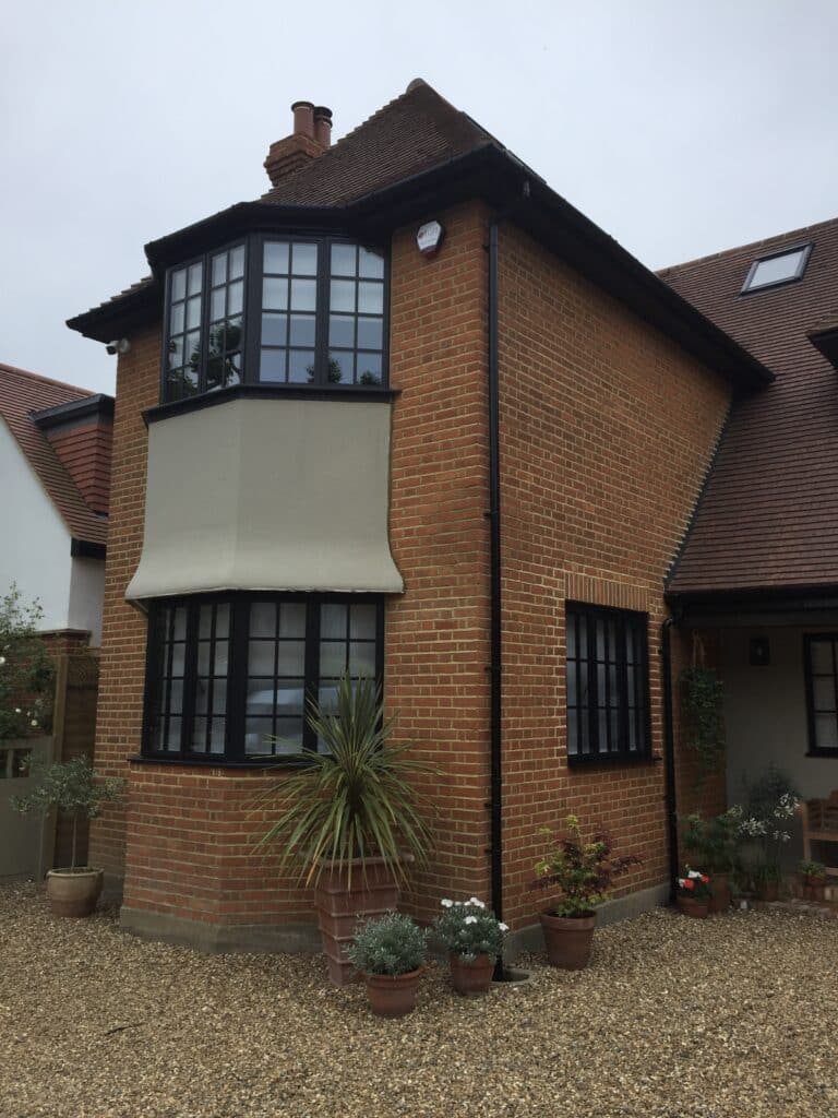 steel replacement windows in a detached post war house, black colour.